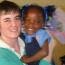 Teaching, holding a child, volunteers having fun,    